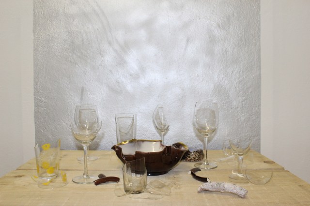 © Renate Egger. Zerbrochene Erinnerungen/Broken memories, 2012. Installation, Fotografie. Gläser, Porzellan, römisches antikes Fragment, Muschel aus Zanzibar auf Holzpaletten/Installation, photography. Glasses, porcelain, roman antique fragment, shell from Zanzibar on wooden pallets